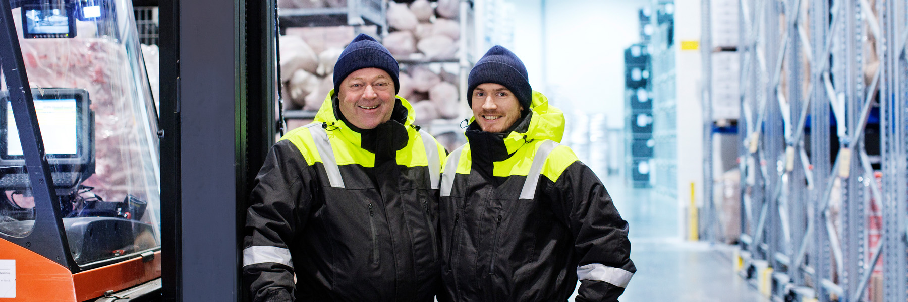 picture of two warehouse workers in protective clothing smiling