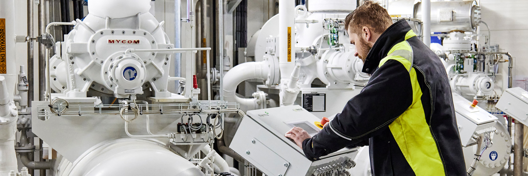 Bild eines Mannes, der eine große Maschine in einem Lagerhaus bedient